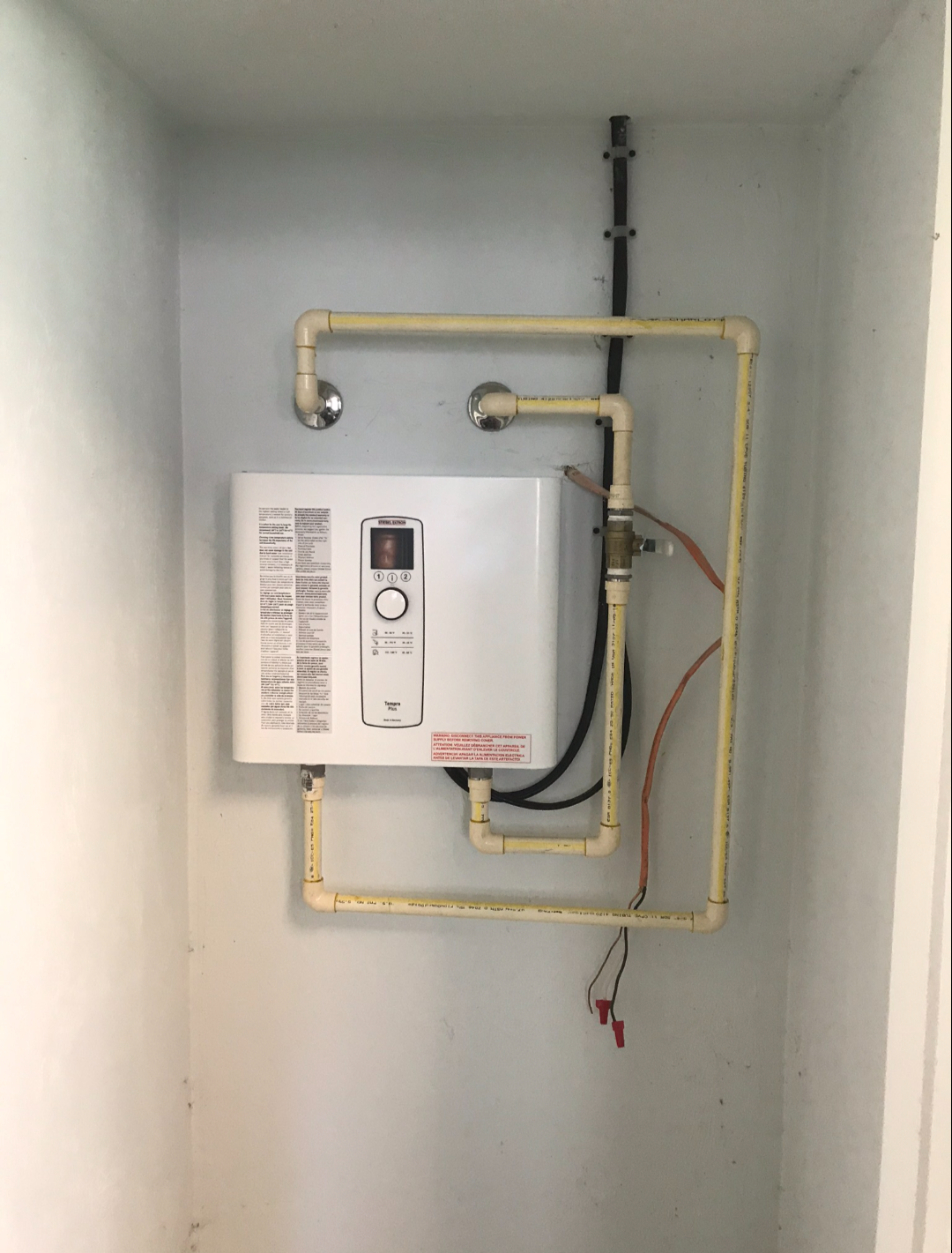 Compact electric water heater installed in a recessed utility closet