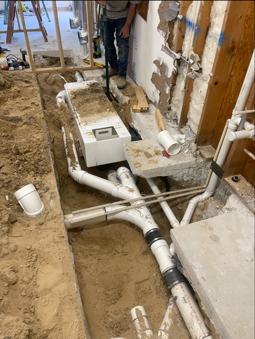 Interior slab cut open with new PVC drain lines reconfigured under the floor