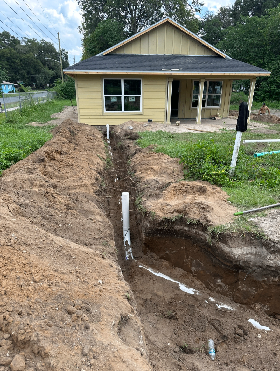 Sewer trench dug from a new construction home out to the street tie-in