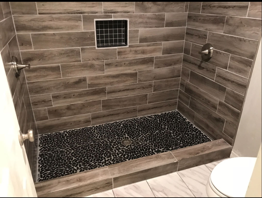 Finished walk-in tile shower with pebble floor