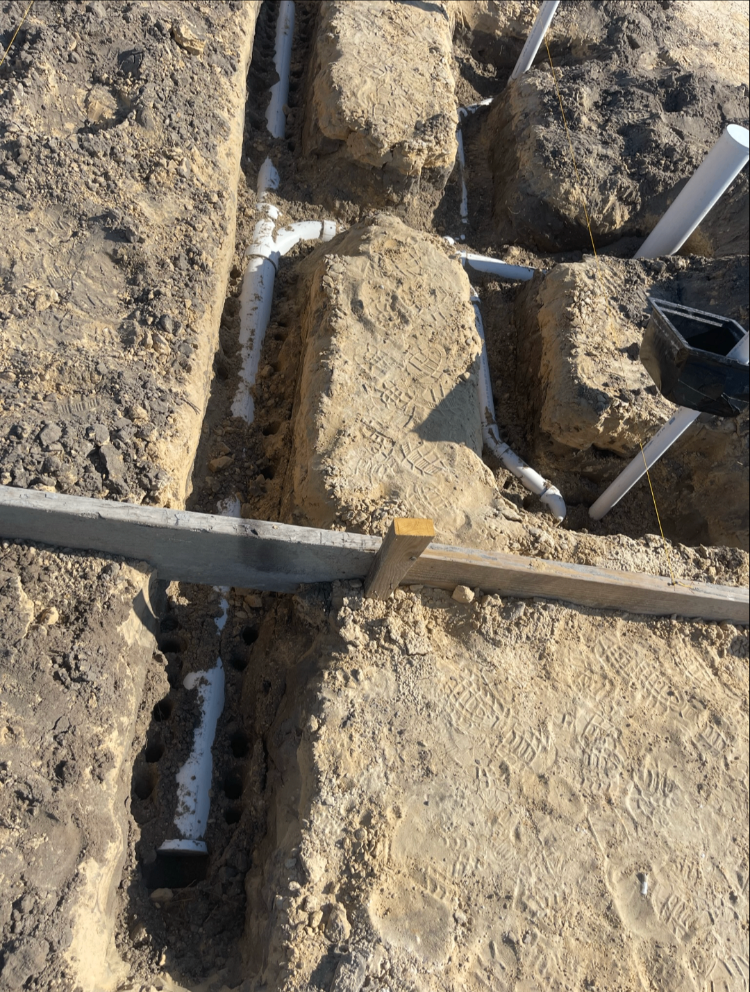 Underground rough plumbing laid out in trenches before slab pour